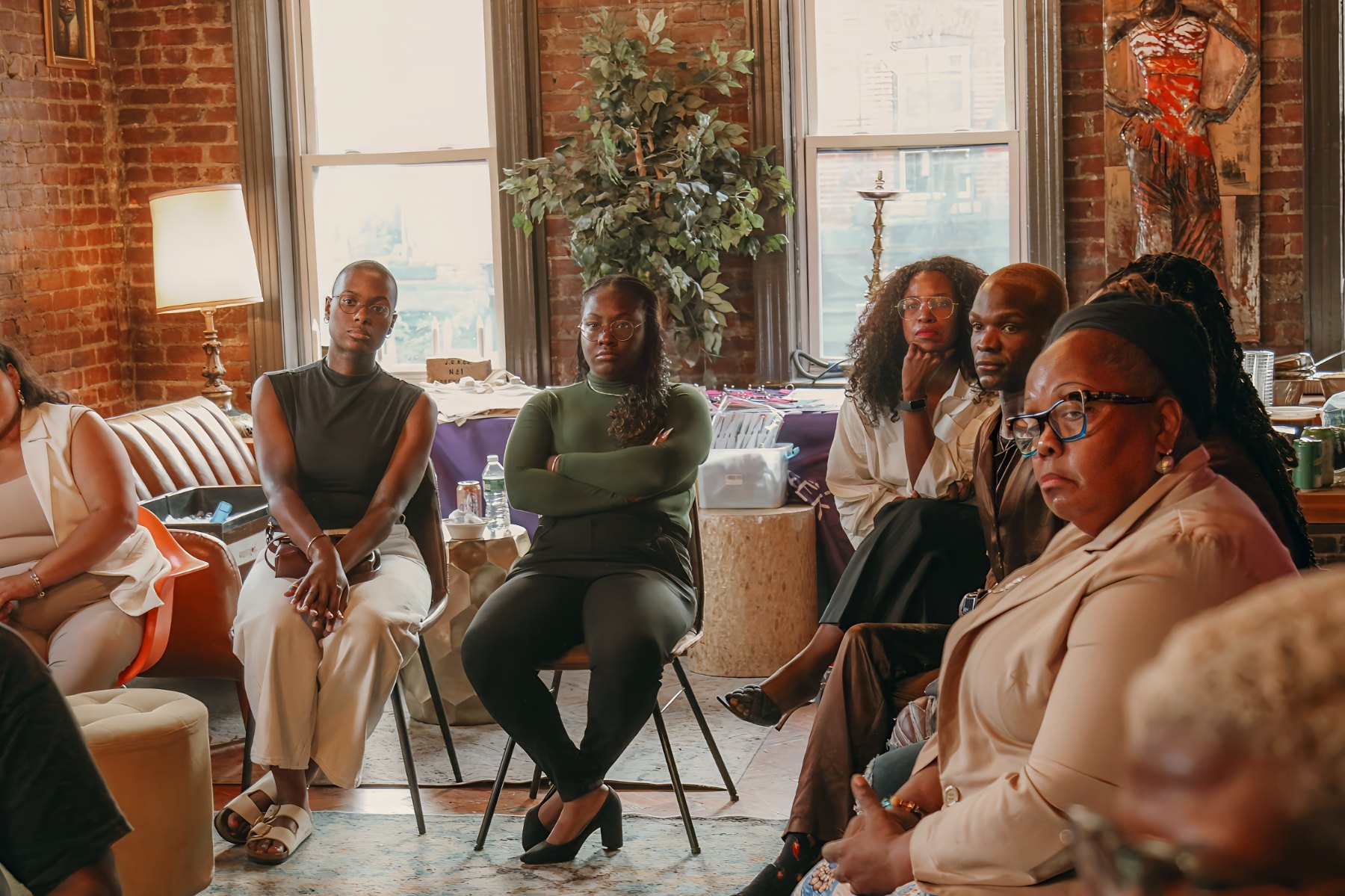 A circle of people seated together at an Oshun Griot community gathering in Jersey City